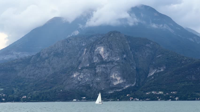Amid vast expanse of Lake Como’s serene waters, an isolated yacht drifts