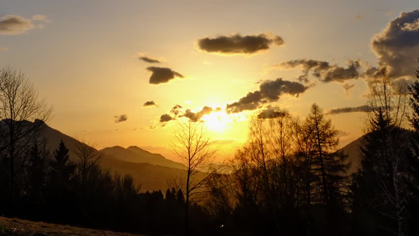 Sunset in a hilly rural landscape on the edge of a forest, Timelapse