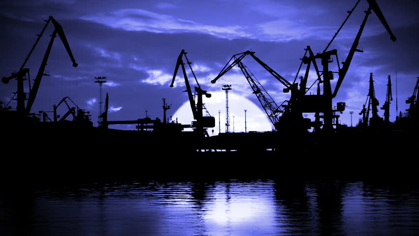 Night. Seaport. Cranes are working. Silhouettes. A huge moon and clouds