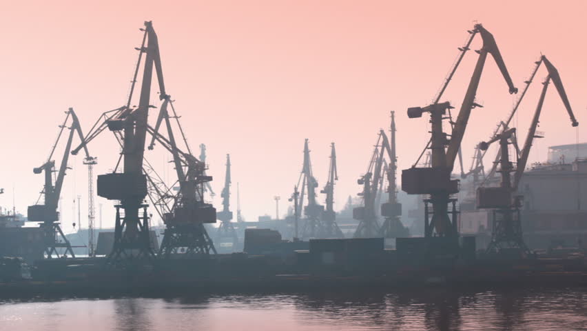 Pink morning. Seaport. Cranes are working