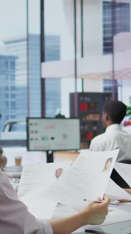 Vertical Video Human resources staff evaluating candidates resume in the selection process, reviewing all applicants after job interview in order to hire the right person. Recruiters seeking personnel