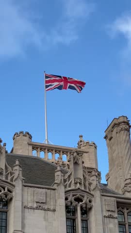British national flag waving on building of Parliament of the United Kingdom. The flag of Great Britain is one of state symbols of state of the UK of Great Britain and Northern Ireland