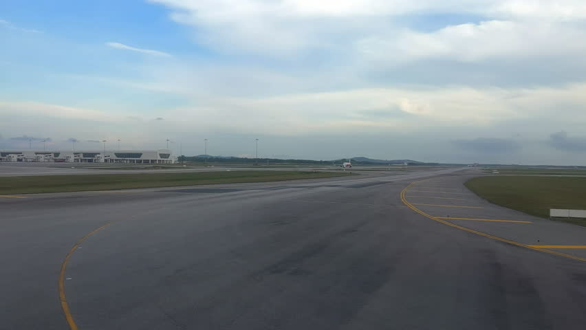 Airplane on a runway. Airplane taxiing for takeoff. Airport terminals with planes on runway. Plane taxiing at airport. Kuala Lumpur, Malaysia.