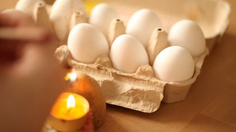 Painting easter eggs with a candle and hot wax - glide Stock Video
