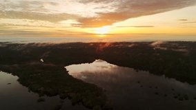 Warm-colored sunrise over Juma River and tropical rainforest of Amazonas, Brazil. Backward ascending drone flight - Powered by Shutterstock - Get 15% off with code: PIKWIZARD15
