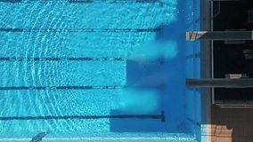 Aerial view of an empty swimming pool with diving platforms, showcasing clear blue water and serene surroundings. Perfect for sports, architecture, and recreation-themed projects - Powered by Shutterstock - Get 15% off with code: PIKWIZARD15