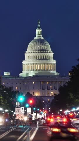 A vertical night timelapse view of traffic activity on Pennsylvania Avenue in Washington, D.C. with the Capitol Dome in the distance.	