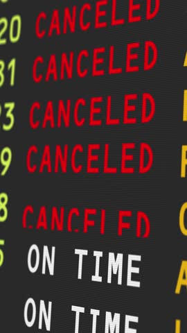 A close-up vertical view of an airport's travel information board with flights being cancelled, possibly due to bad weather conditions.	