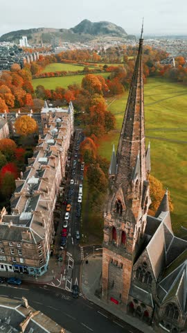 A fly away overlooking a picturesque cathedral and colorful trees in Edinburgh