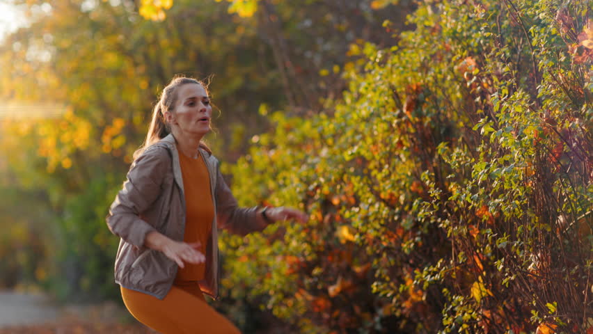 Hello autumn. modern female in fitness clothes in the park training.