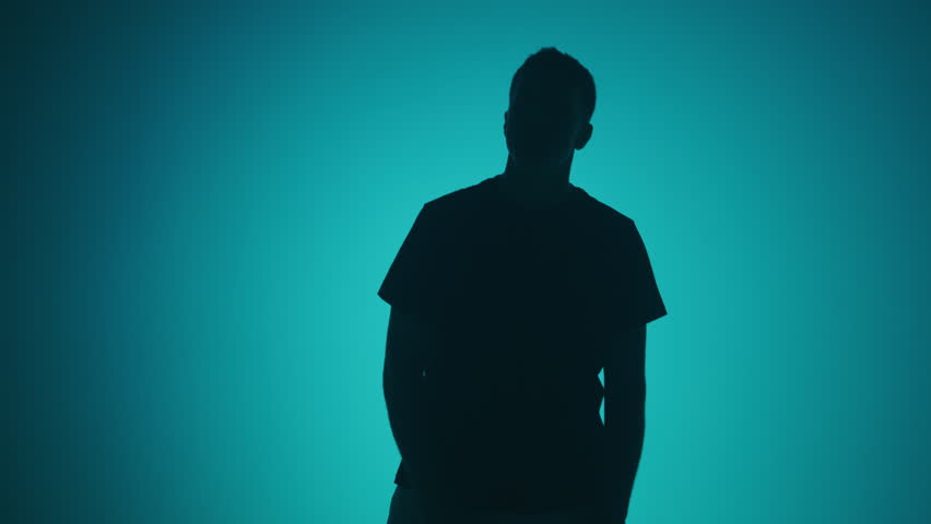 Medium shot silhouette of a rap artist singing on a color changing background. 4k high resolution footage. 