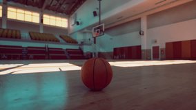 An old basketball lays unused on the floor of an empty gym. - Powered by Shutterstock - Get 15% off with code: PIKWIZARD15