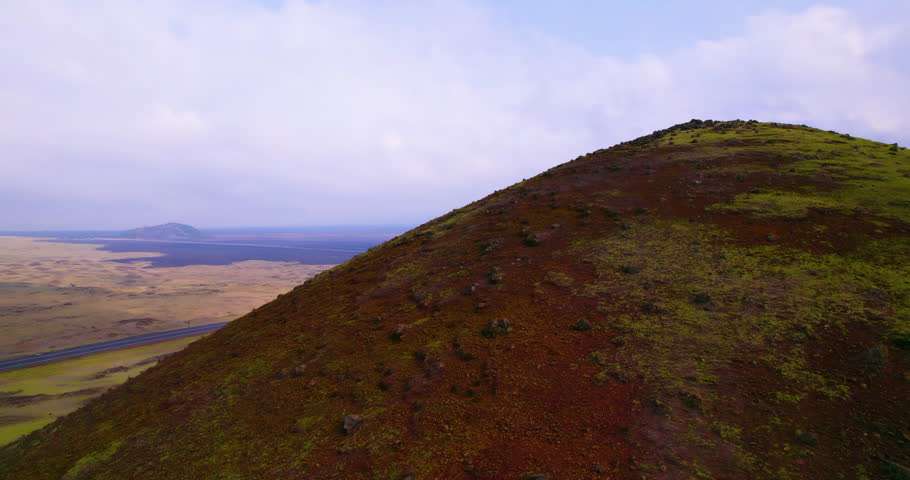 Aerial view panning left over hills near rural highway in Kona Hawaii 