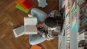 Top view African American man looking at camera reading book preparing for exam student learning study educate smile library literature academic bookshelves bookshop campus cognition information male - Powered by Shutterstock - Get 15% off with code: PIKWIZARD15