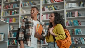 Two people African American man latin hispanic woman talking library reading club literature students bookstore bookshelves communication smiling discussing holding books female male university study - Powered by Shutterstock - Get 15% off with code: PIKWIZARD15