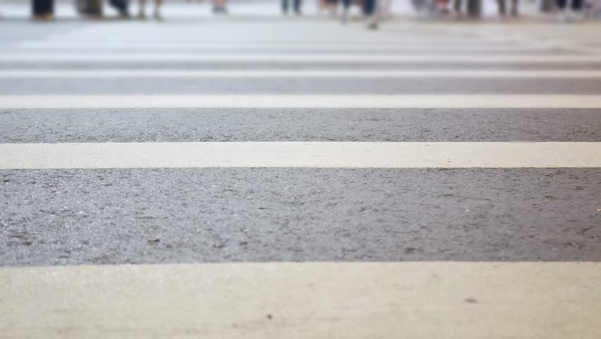 low anngle view while crossing the street at zebra crossing in downtown Taipei in Taiwan in night time, street cross walk in rush busy hour among big city of Taiwan