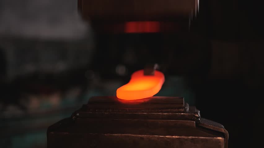 Craft workshop for manufacture of metal structures. blacksmith is working.  handmade forge. master makes iron products, beats hot metal with an industrial hammer and gives shape