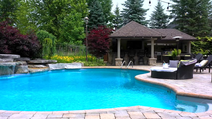 Capture the essence of outdoor luxury with this 4K video of a stunning pool and backyard oasis. Perfect for real estate, design, and creative projects. High-quality visuals, lush landscaping, modern.