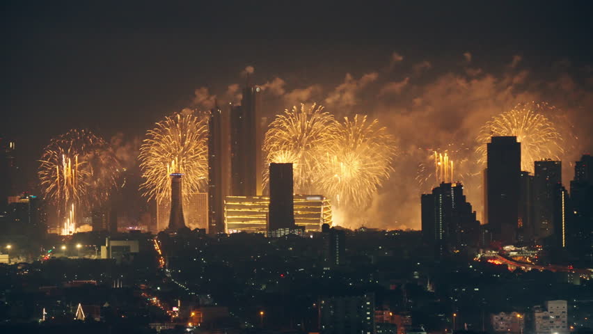 Beautiful annual happy new year festival with firework display glowing over iconic department store, illuminated building in downtown during midnight time at Bangkok, Thailand