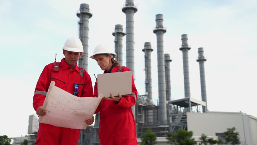 Team engineer discussion inside Electricity Power Plant site. Senior Engineer wearing safety jacket and PPE working about Petro Chemical plant