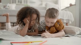 Little African girl and Caucasian boy watching educational video in mobile app. Multiracial children in kindergarten, spending time online, using smartphone with internet connection, modern technology - Powered by Shutterstock - Get 15% off with code: PIKWIZARD15