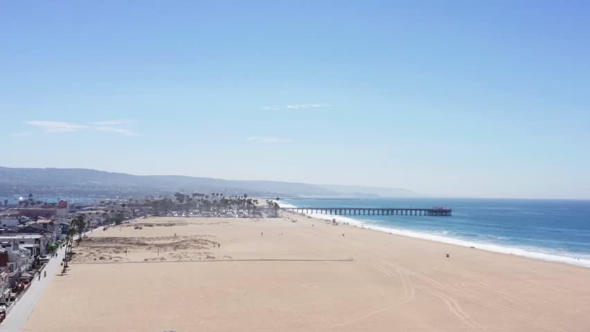 Aerial tracking shot of Balboa Beach alongside the town of Newport Beach, California