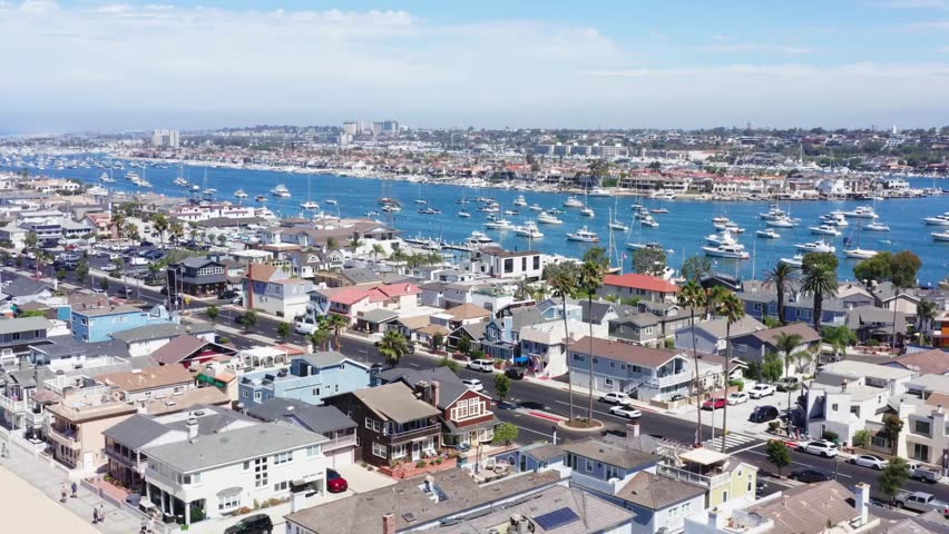 Aerial paralax shot showing sailboats moored along the Balboa Peninsula in Newport Beach, California