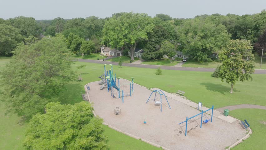 Pan drone shot of a vacant exercise area on green ground with beautiful natural landscape at background in Minnesota, USA.