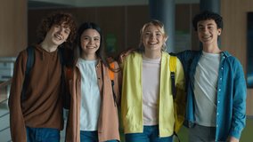 Happy smiling Caucasian four friends students teenagers students teens girls boys guys women men cuddling laughing standing together school university college talking friendship study smile at camera - Powered by Shutterstock - Get 15% off with code: PIKWIZARD15