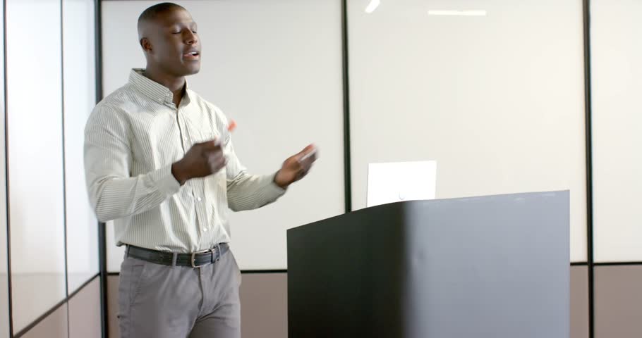 Lifestyle videos indoor of people doing activities at office, presenting in office, man holding marker and speaking at podium. giving presentations, side angle, half body, writing on the board