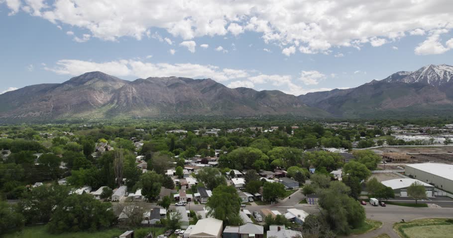 Ogden, utah with lush green landscape, residential area, and mountains in the background, aerial view