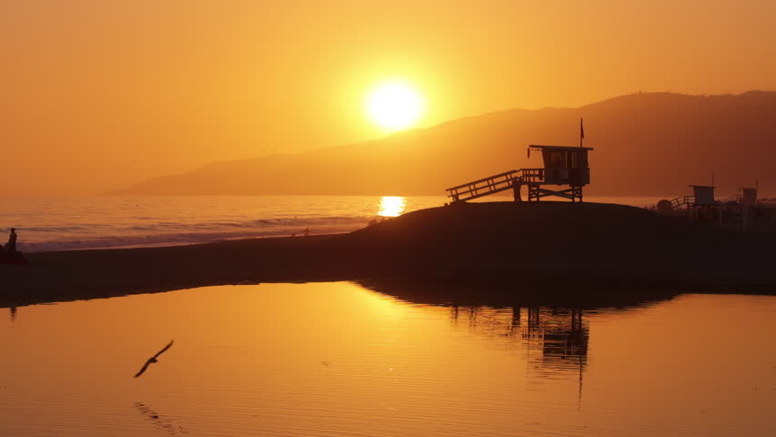 Experience the beauty of a captivating sunset over the serene shores of Malibu, California, USA. This picturesque scene captures the essence of the west coast in stunning 4K resolution