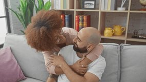 Interracial couple embracing joyfully in a cozy modern living room, expressing love and happiness - Powered by Shutterstock - Get 15% off with code: PIKWIZARD15