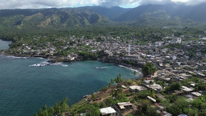 Aerial view of Domoni town in Anjouan volcanic island in the Comoro Islands Indian Ocean, drone approaching the bay village built around the main mosque