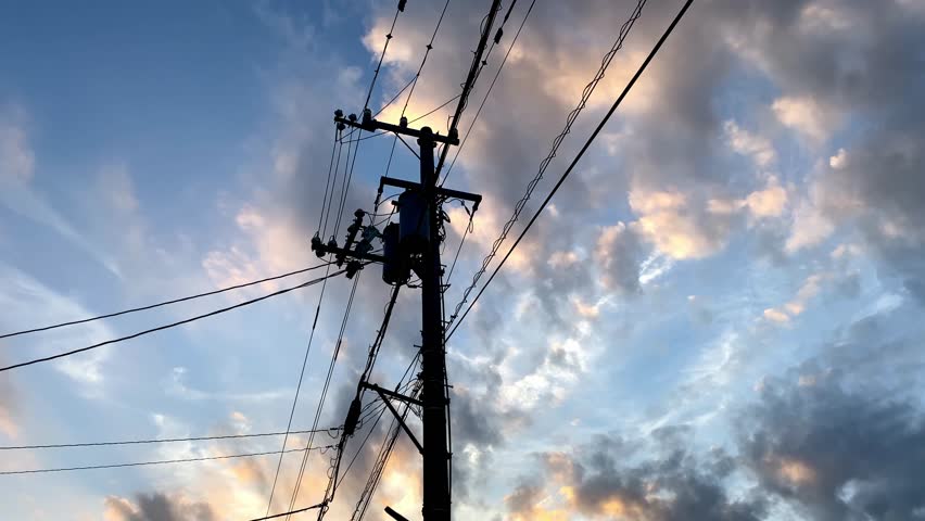 Silhouette of clouds and telephone poles in red at dusk