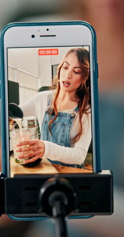 Woman, influencer or live streaming with phone screen for smoothie, tutorial or online class at home. Female person, vlogger or freelancer recording tip or drink on diet or mobile smartphone at house