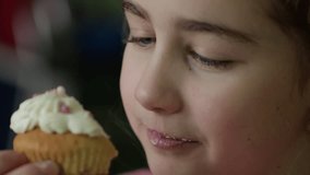 Child Eating Muffins Cupcakes Decorated With Sugar Cream. Girl Enjoying Vanilla Cupcakes with Frosting and Sprinkles. Unhealthy Junk Food. Hungry Sweet Tooth Child Bites Muffin with Sugar Frosting. - Powered by Shutterstock - Get 15% off with code: PIKWIZARD15