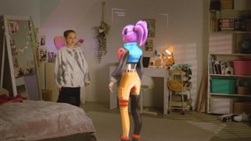Teen girl talks to virtual reality hologram in metaverse AI chat, shows gymnastics skills in bedroom. Futuristic 3D graphics of animated avatar. Technology of AI friend simulation. Augmented reality. - Powered by Shutterstock - Get 15% off with code: PIKWIZARD15