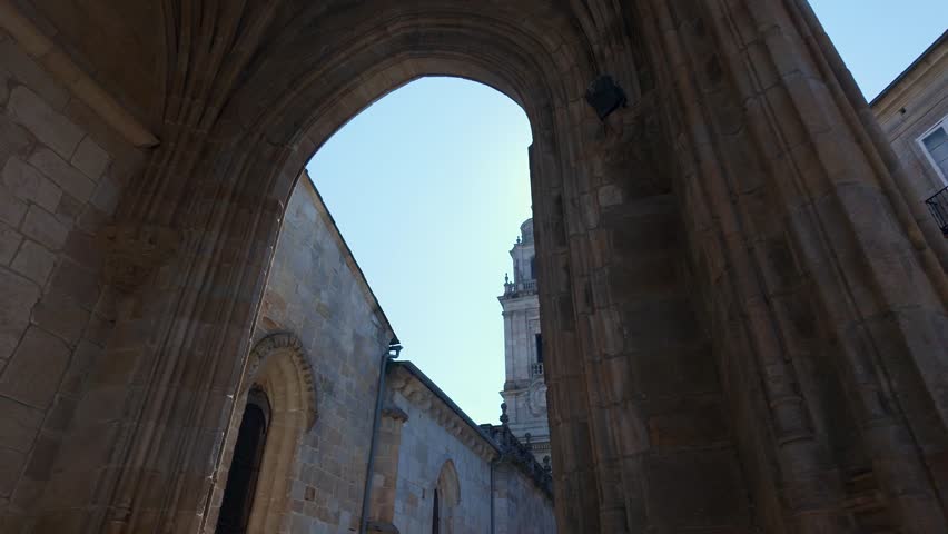 Lugo Cathedral Tower seen from a large stone arch of the city, Galicia.