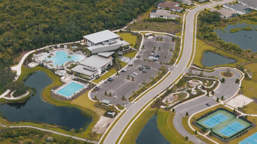 Aerial footage of a community entertainment center with pools and tennis courts