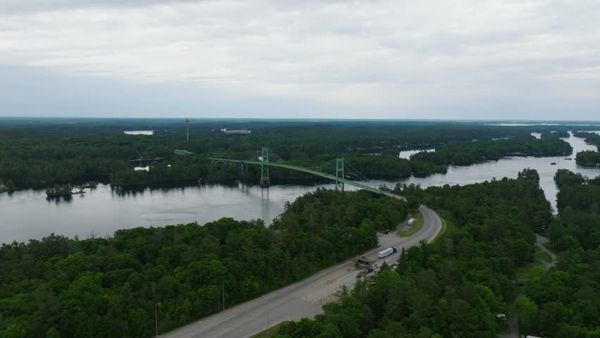 Aerial view of Thousand Islands International Bridge between US and Canada on St. Lawrence River from New York to southeastern Ontario over water and forests in summer green beautiful vehicle crossing