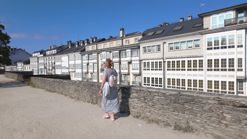 Female tourist with her back walking over the Roman wall of Lugo, a World Heritage Site.