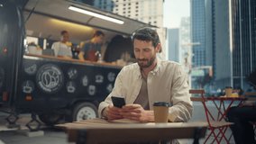 Caucasian Man Sitting in a Street Cafe, Sipping Coffee, Using a Smartphone. Handsome Male Browsing Internet, Texting Friends and Colleagues, Shopping Online and Reading Social Media - Powered by Shutterstock - Get 15% off with code: PIKWIZARD15