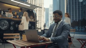 Portrait of a Thoughtful Black Man Working Remotely from an Outdoors Cafe. Businessman Using Laptop Computer, Feeling Inspired to Write a Perfect Pitch or Business Proposal - Powered by Shutterstock - Get 15% off with code: PIKWIZARD15