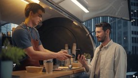 Caucasian Customer Buying Coffee and Snacks To Go From a Trendy Street Cafe in a Modern City Neighbourhood. Barista Serves Order with a Smile, Client Makes a Transaction with His Smartphone - Powered by Shutterstock - Get 15% off with code: PIKWIZARD15