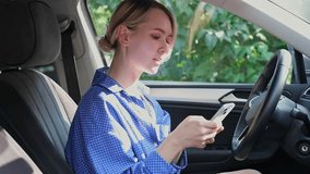 Driver woman in the car is using her mobile phone. Cheerful young blond woman is sitting into a vehicle with a smartphone in the hand and talking to the phone via video call - Powered by Shutterstock - Get 15% off with code: PIKWIZARD15