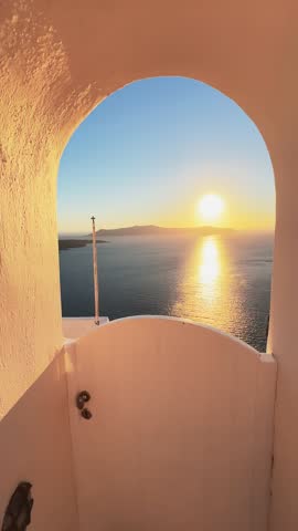 Beautiful sunset in Santorini island, Greece. White architecture with sea view. Summer travel and vacation. Vertical video
