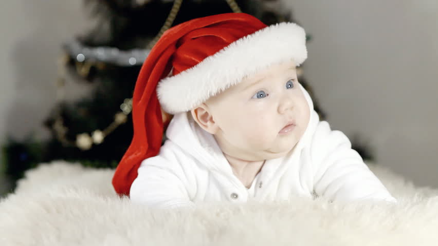 Baby in Christmas hat on the new year background