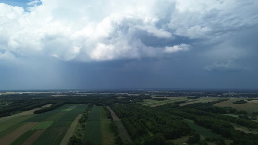 Expansive fields beneath looming storm clouds