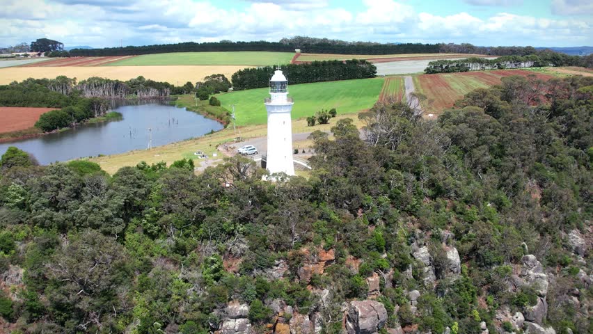 Lighthouse and colorful fields in the background in Tasmania, Australia. View from above.
